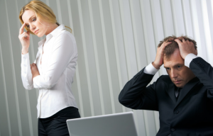 two people facing a computer looking very stressed as they look at their credit reports and see credit defaults