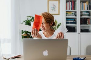 Angry and confused lady infront of a computer, frustrated because she doesn't know the difference between a sercured loan and a unsecured loan.